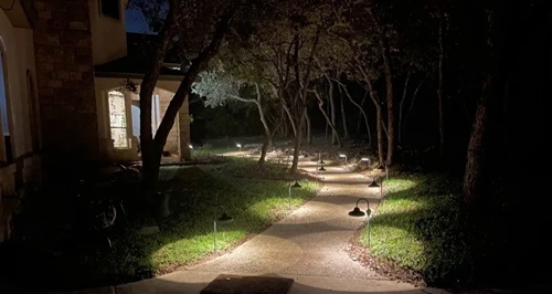 Finished walkway lighting glowing at night in a front yard
